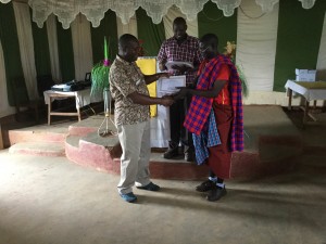 Frank and Pastor David present a certificate to a Masai participant