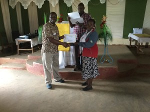 Frank awards a certificate to a Masai woman.