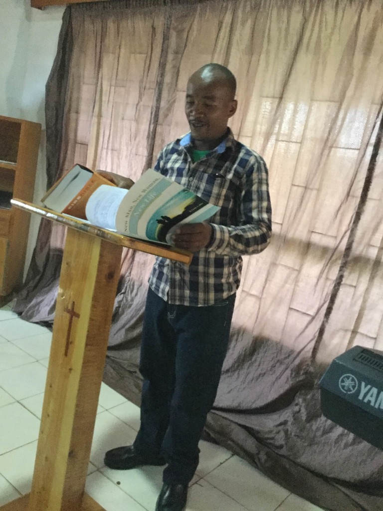 Roy, who will graduate from Teen Challenge, holds a Bible and the Empower study guide.